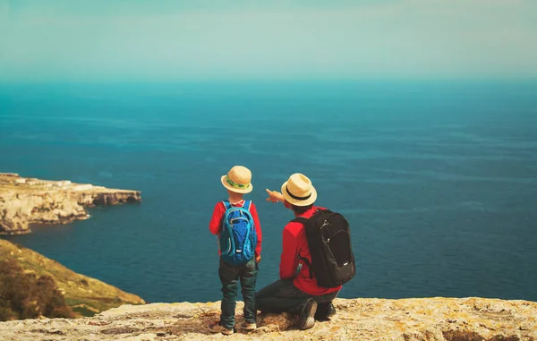 Viagens em família - pai e filho caminhando em montanhas no mar — Fotografia de Stock