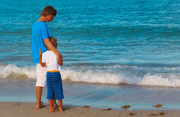 Crianza de los hijos y vacaciones en la playa- pequeño hijo abrazando padre en el mar — Foto de Stock