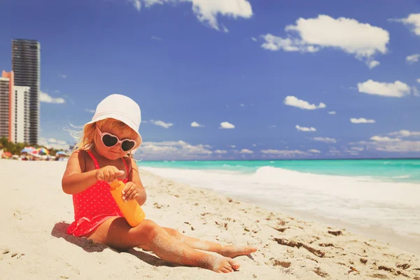 Ochrona przed słońcem - dziewczynka z kremów z filtrami krem na plaży — Zdjęcie stockowe