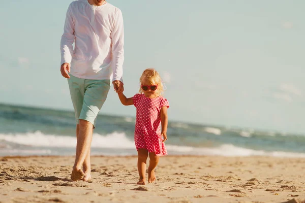 Vader en dochtertje wandelen op strand — Stockfoto