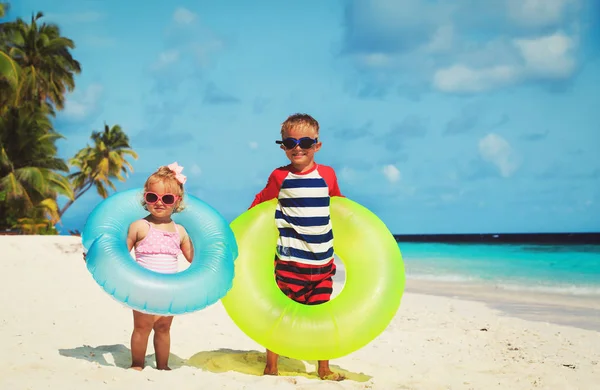 Sevimli küçük çocuk ve bebek kız oyun beach — Stok fotoğraf