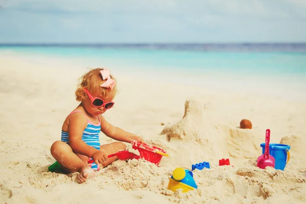 Menina bonito brincando com areia na praia — Fotografia de Stock