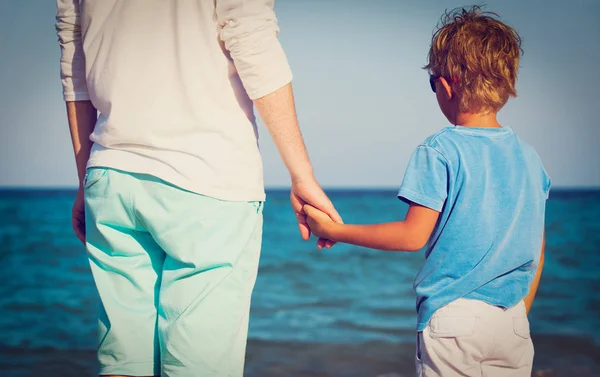 Vader en zoontje hand in hand op strand — Stockfoto