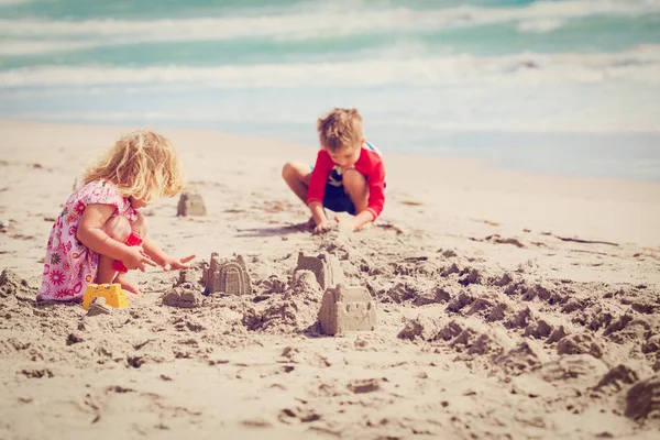 Kisfiú és a lány játszani homok a nyári strand — Stock Fotó