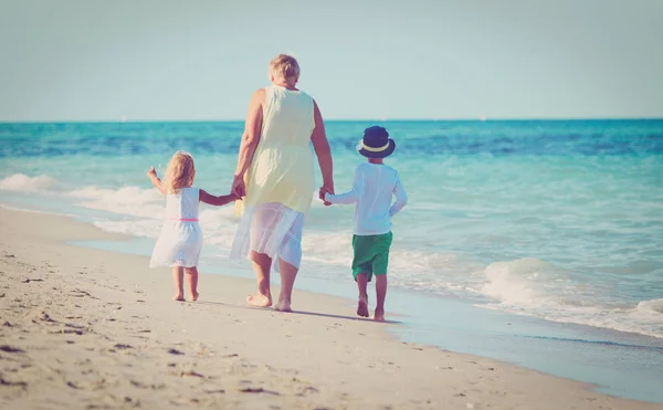 Oma met kinderen - kleine jongen en meisje-op strand — Stockfoto