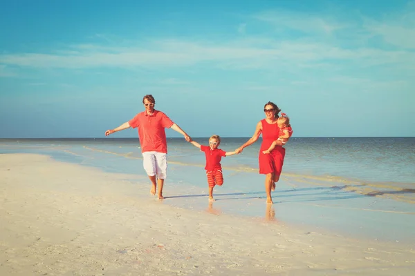 Familia con dos niños divirtiéndose en la playa — Foto de Stock