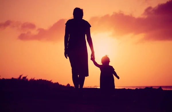 Mother and little daughter walking at sunset — Stock Photo, Image