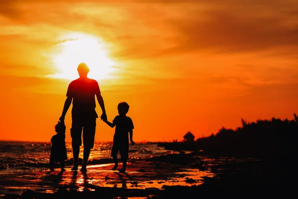 Father and two kids walking at sunset — Stock Photo, Image