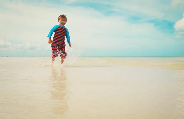 Niño pequeño disfrutar jugar con el agua en la playa —  Fotos de Stock