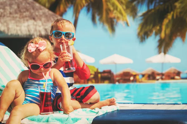 Kids relax on tropical beach resort and drink juices — Stock Photo, Image