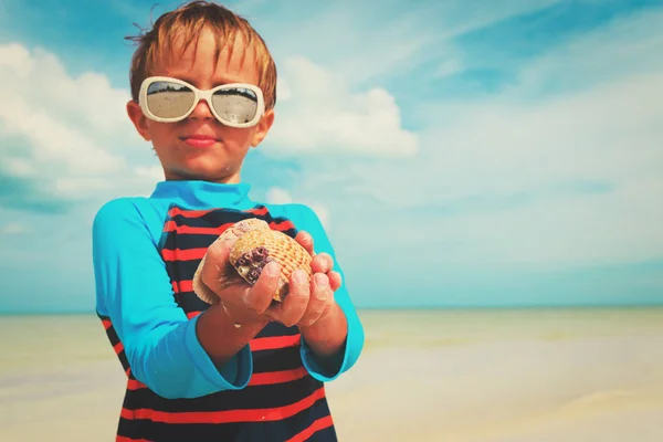 Гордий маленький хлопчик знайшов мушлі на пляжі — стокове фото