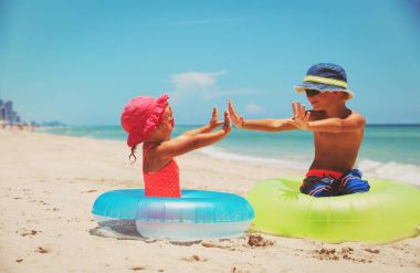 sevimli küçük erkek ve kız plajda oyna