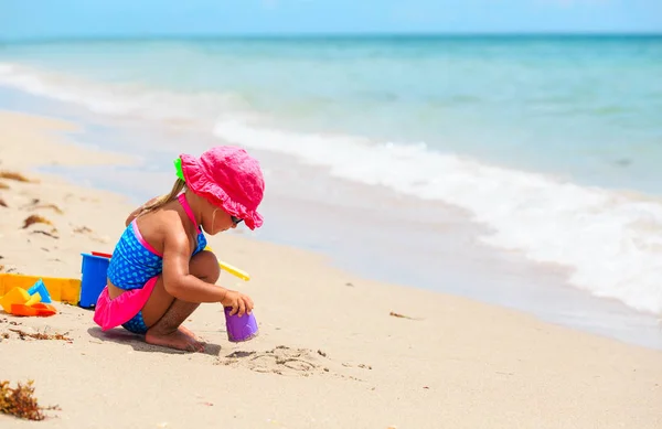 Schattig klein meisje spelen met zand op het strand — Stockfoto