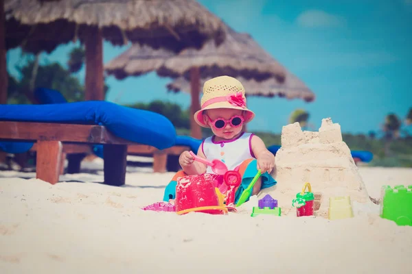 Gadis kecil yang lucu bermain dengan pasir di pantai — Stok Foto