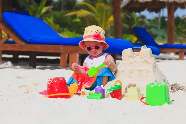 Söt liten flicka leka med sand på stranden — Stockfoto