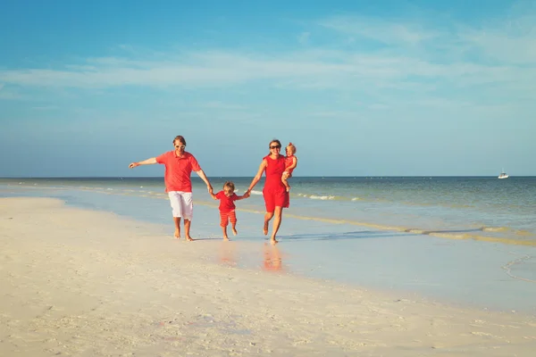 Familia con dos niños divirtiéndose en la playa — Foto de Stock