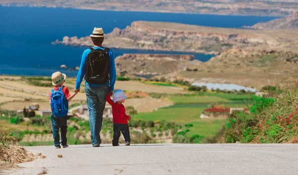 Father with two kids walking on scenic road — Stock Photo, Image