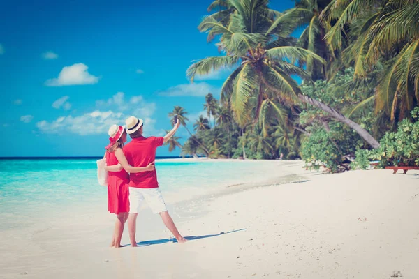 Unga lyckliga paret att göra selfie på stranden — Stockfoto