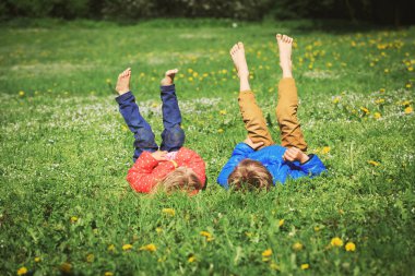 Küçük oğlan ve kız yeşil çimlerde rahatlar.