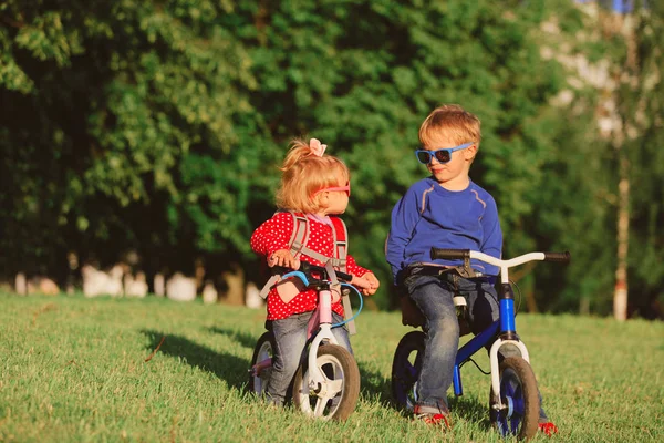 Kleine Jungen und Mädchen auf Fahrrädern in der Natur — Stockfoto