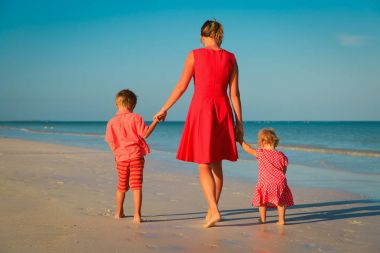Anne ile küçük oğlu ve kızı yürüyüş sahilde