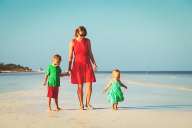 Anne ile küçük oğlu ve kızı yürüyüş sahilde