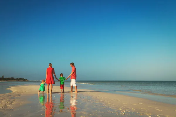 Gelukkig gezin met twee kinderen lopen op strand — Stockfoto