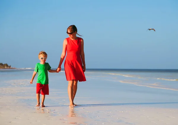 Moeder en zoon lopen op strand — Stockfoto