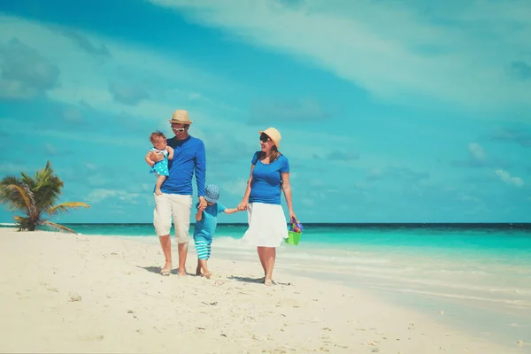 Gezin met twee kinderen lopen op strand — Stockfoto