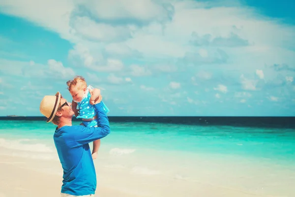 Vader en dochtertje spelen in de lucht op het strand — Stockfoto