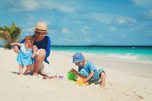 Father with little daughter and son play on beach — Stock Photo, Image