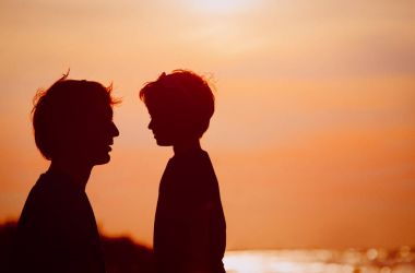 Baba ve küçük oğlu siluetleri gün batımında