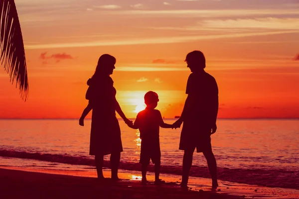Familia feliz con dos niños en la playa del atardecer — Foto de Stock