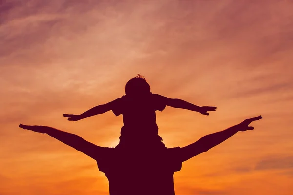 Father and son play on sunset sky — Stock Photo, Image