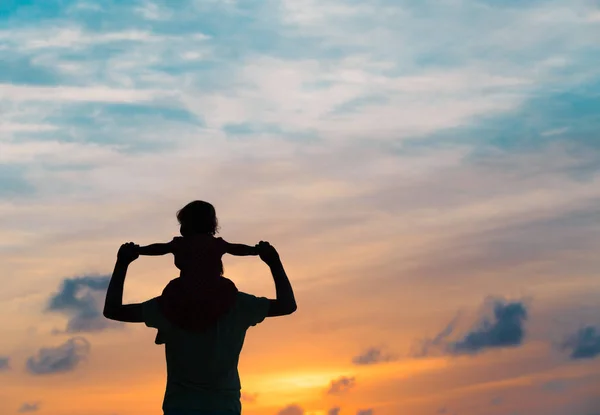 Vader en dochter silhouetten spelen bij zonsondergang — Stockfoto