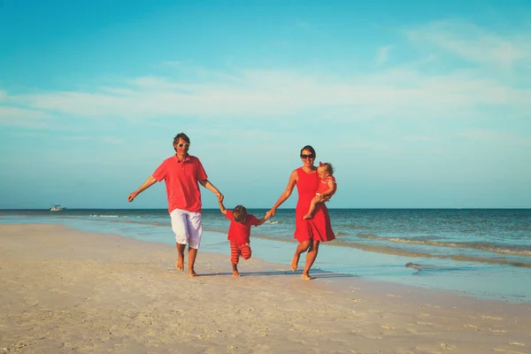 Familia con dos niños divirtiéndose en la playa — Foto de Stock