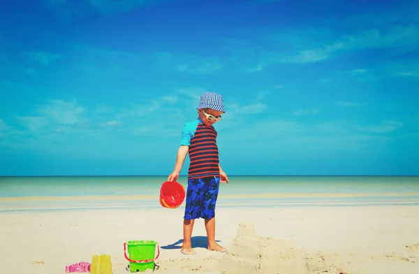 Niño pequeño jugar con arena en la playa —  Fotos de Stock