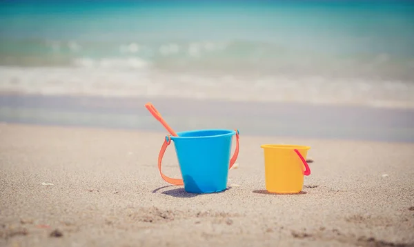 Juguetes para niños en la playa de arena tropical — Foto de Stock