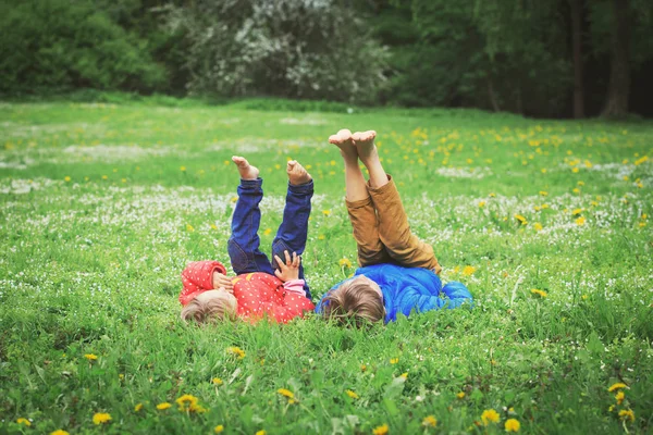 Mały chłopiec i dziewczyna zrelaksować się na zielonej trawie — Zdjęcie stockowe