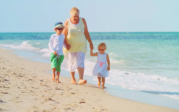 Gelukkig oma met kinderen op strand — Stockfoto