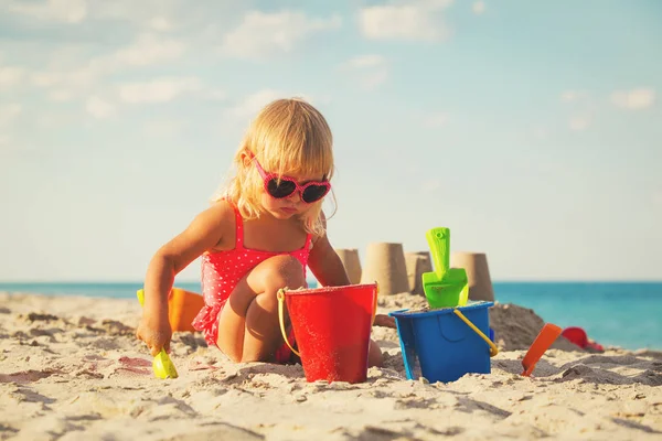 Schattig klein meisje spelen met zand op het strand — Stockfoto