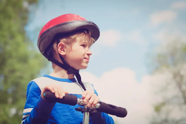 Mignon petit garçon avec casque scooter d'équitation — Photo
