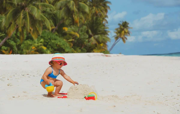 可愛い女の子が砂浜で遊ぶ — ストック写真