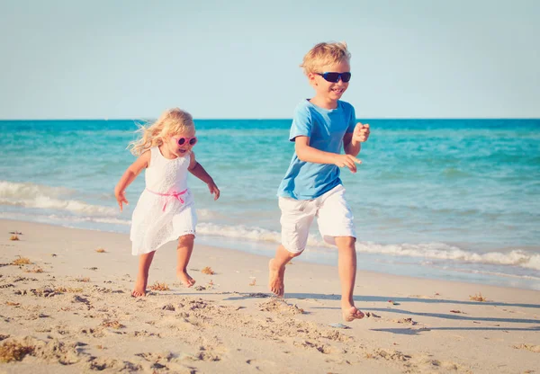 Mały chłopiec i dziewczynka uruchomiona na plaży — Zdjęcie stockowe