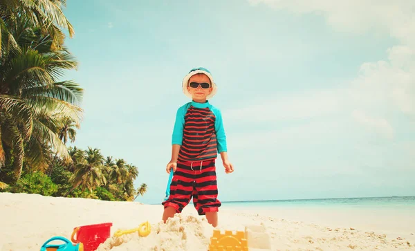 Menino brincar com areia na praia — Fotografia de Stock