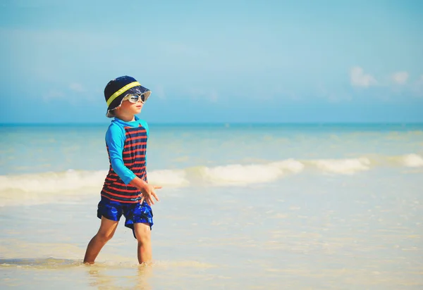 Bambino passeggiata giocare con l'acqua sulla spiaggia — Foto Stock