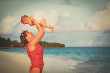 Anne ve kumsalda oynarken kızım