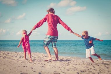 babası küçük oğlu ve kızı ile oynamak plaj