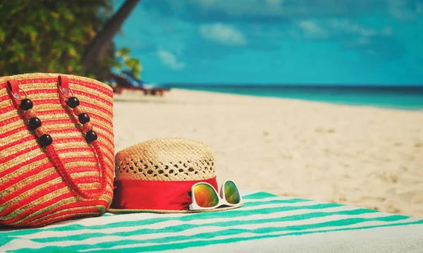 Cappello, occhiali da sole e borsa sulla spiaggia — Foto Stock