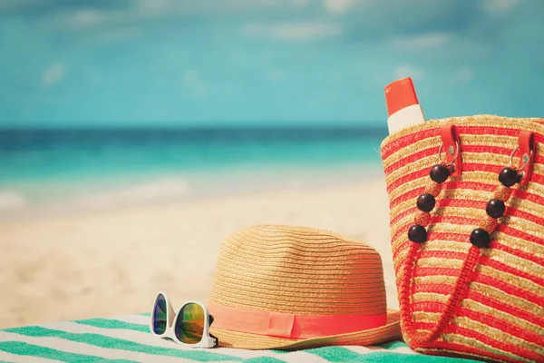 Шляпа, солнцезащитные очки и сумка с кремом для загара на пляже — стоковое фото